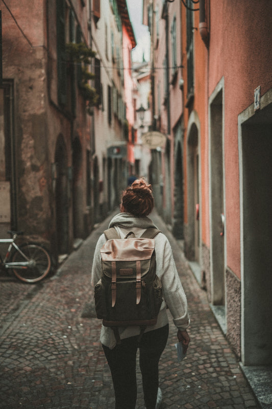woman walking on street surrounded by buildings